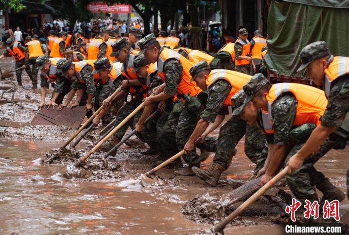 7月4日，萬州區五橋街道，武警官兵清理街道上的淤泥。　冉孟軍 攝
