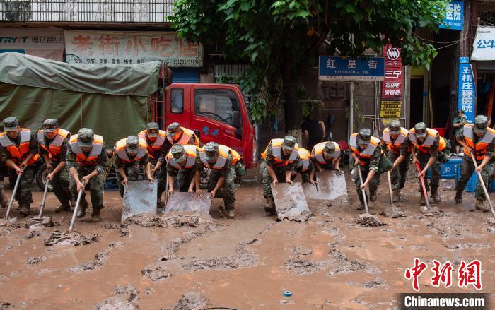 7月4日，萬州區五橋街道，武警官兵清理街道上的淤泥。　冉孟軍 攝