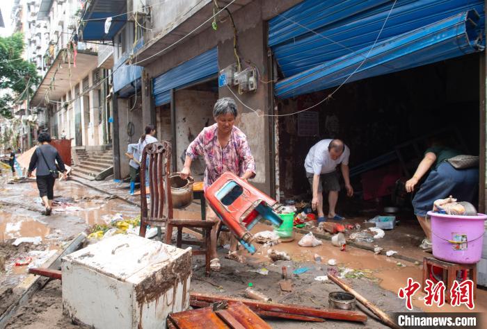 7月4日，萬州區五橋街道，洪水退去后，居民搶救生活物資?！∪矫宪?攝