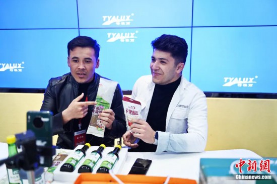 2023年3月，甘肅省慶陽市環(huán)縣電商創(chuàng)業(yè)孵化基地內(nèi)，來自蘭州文理學(xué)院的塔吉克斯坦留學(xué)生正在協(xié)助主播直播帶貨當(dāng)?shù)剞r(nóng)特產(chǎn)品。李亞龍 攝