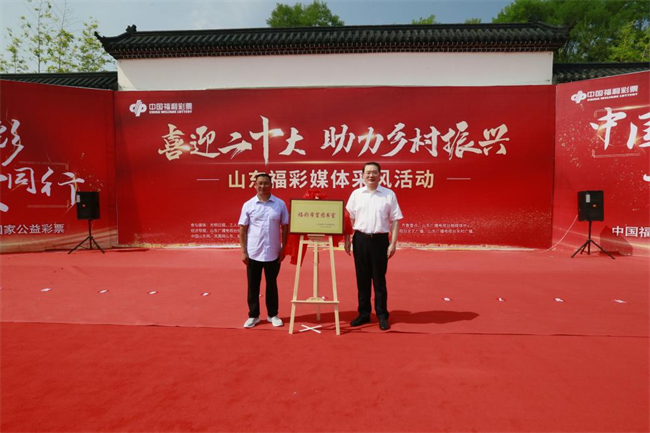 省福彩中心主任王偉與沂源縣徐家莊中心學校校長傅懷佳共同為“福彩希望圖書室”揭牌。 山東省福彩供圖)