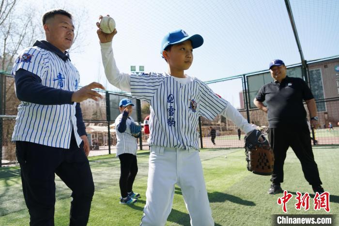 圖為教練指導(dǎo)小棒球手?jǐn)S球技術(shù)。　馬銘言 攝