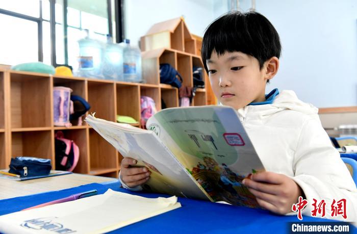 3月14日，西藏拉薩市第一小學一年級六班學生丁增樂吉在閱讀藏語課本。　李林 攝