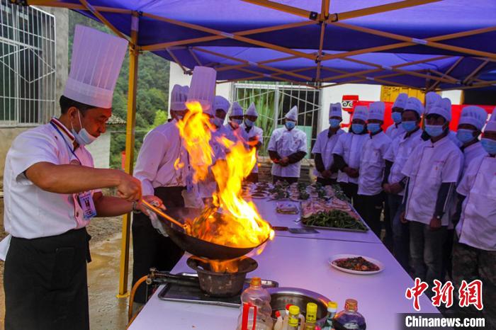 喜德縣冕山鎮舉辦的廚師培訓班上，老師正在示范回鍋肉的做法。　爾古木三 攝