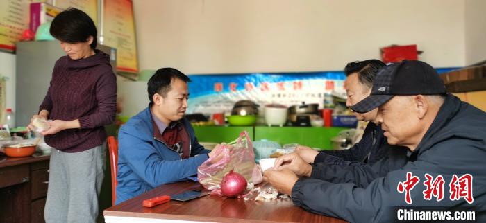 圖為扶貧路上“臨時(shí)一家人”準(zhǔn)備午餐。　魏建軍 攝