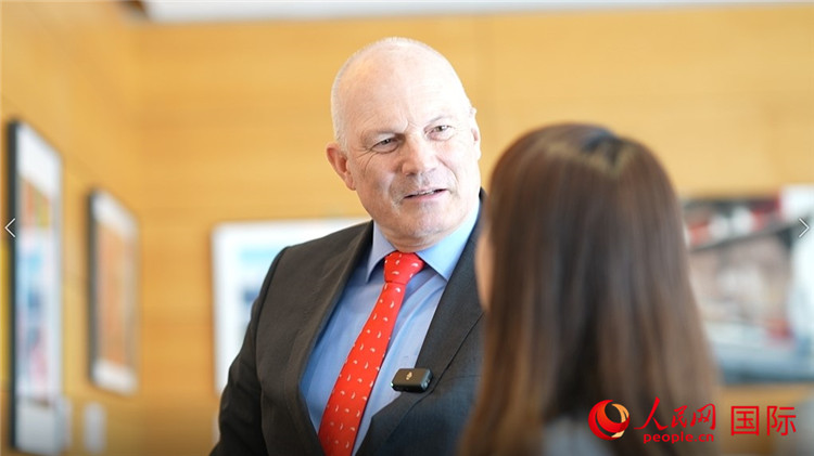 瑞士駐華大使白瑞誼介紹使館內陳列的照片。人民網 彭昱凱攝