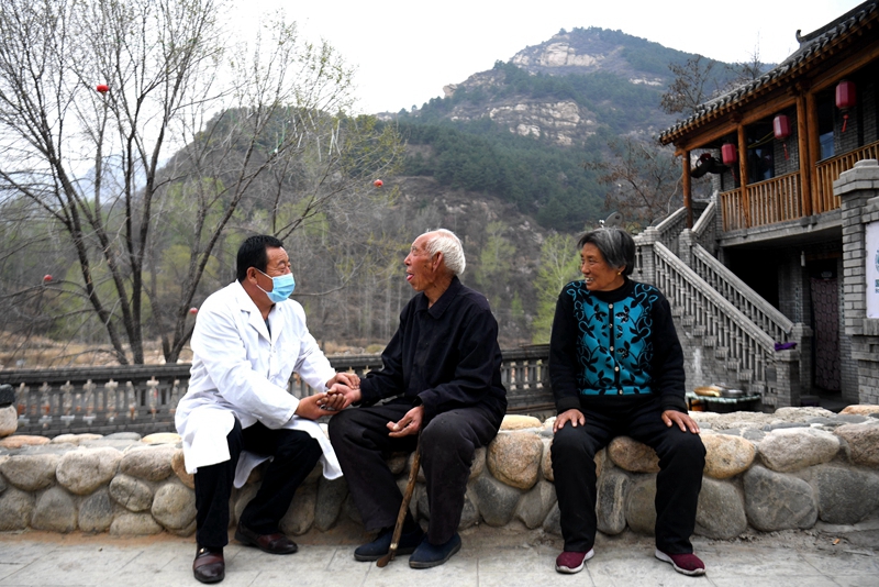 2020年4月15日，在河北阜平縣龍泉關鎮駱駝灣村，村醫霍建國為村民把脈。