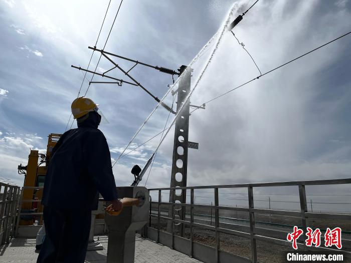 圖為高壓水槍的水柱沖洗絕緣子串。 高啟宏 攝
