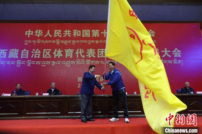 西藏自治區副主席甲熱·洛桑丹增授代表團團旗，西藏自治區體育局局長尼瑪次仁接旗?！∪轿木?攝
