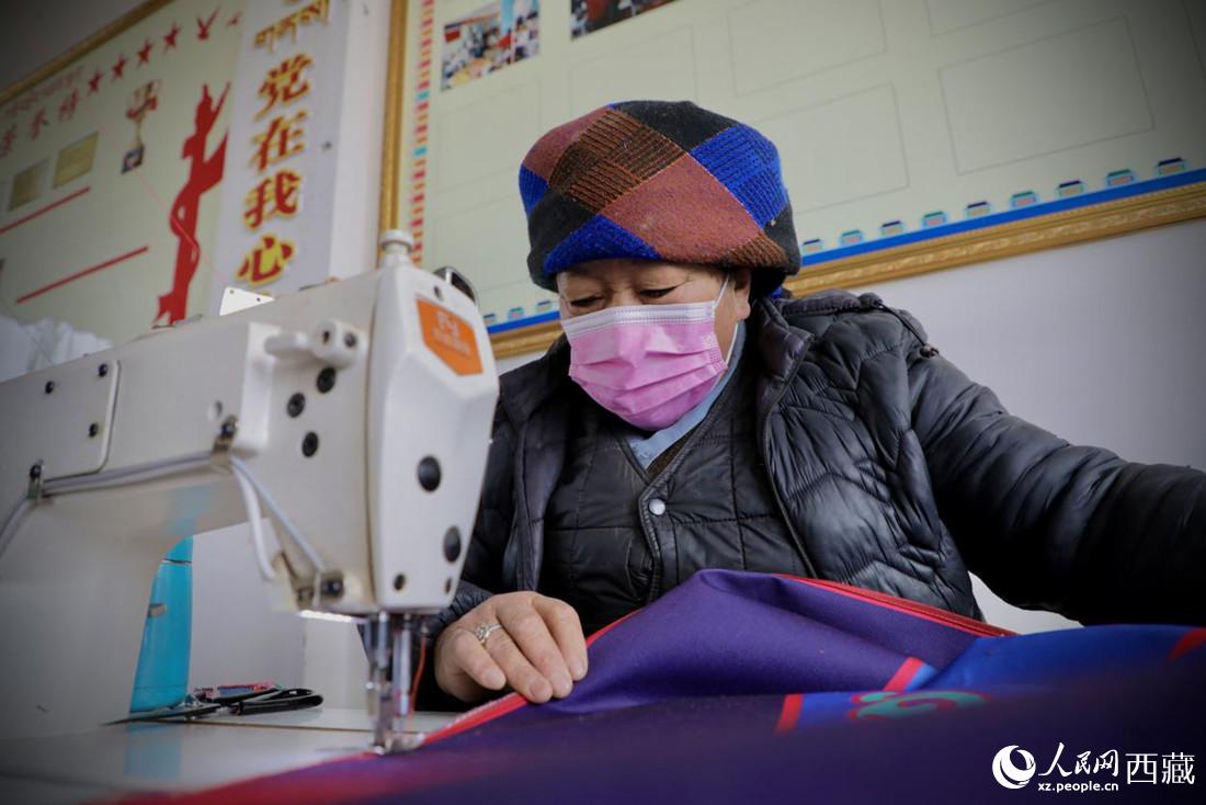 農牧民專業合作社里的村民正在制作門簾。人民網 次仁羅布攝
