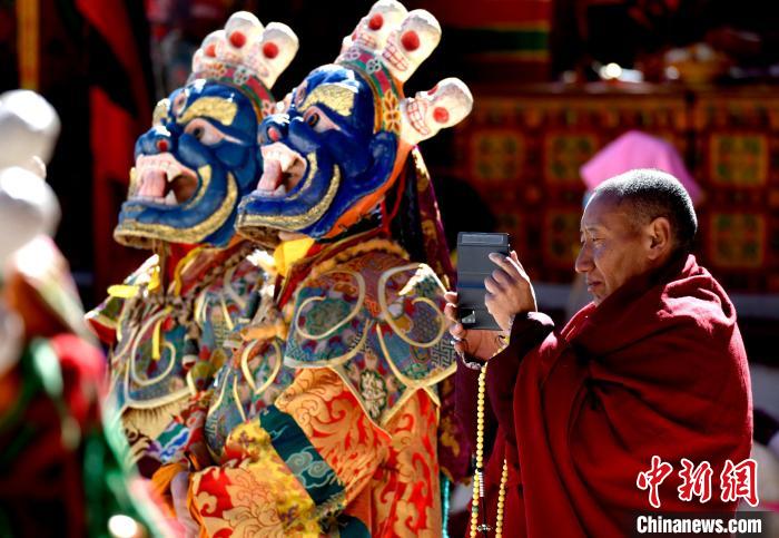 2月19日,正在拍攝跳神活動的僧人。 李林 攝