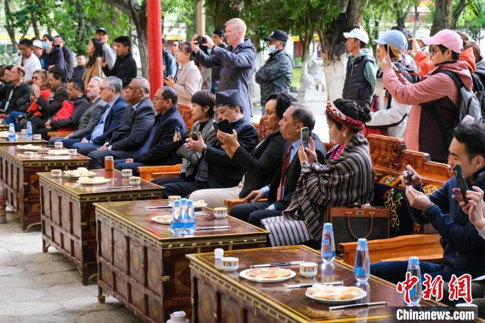 5月19日,中外嘉賓在羅布林卡和游客一起觀看藏戲。 江飛波 攝