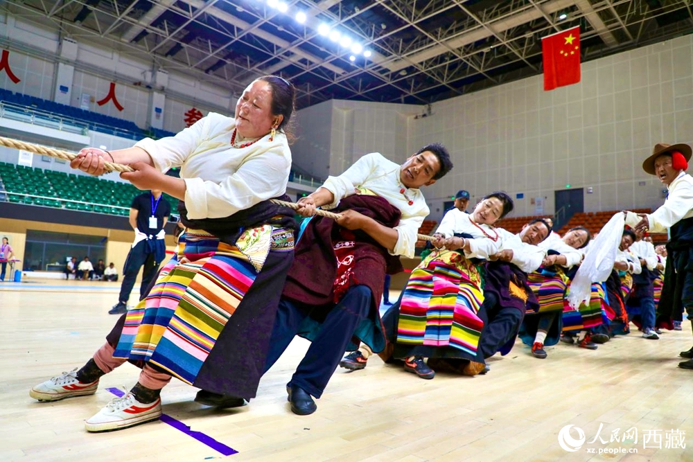 身著民族服裝的農(nóng)牧民選手在拔河比賽現(xiàn)場。
