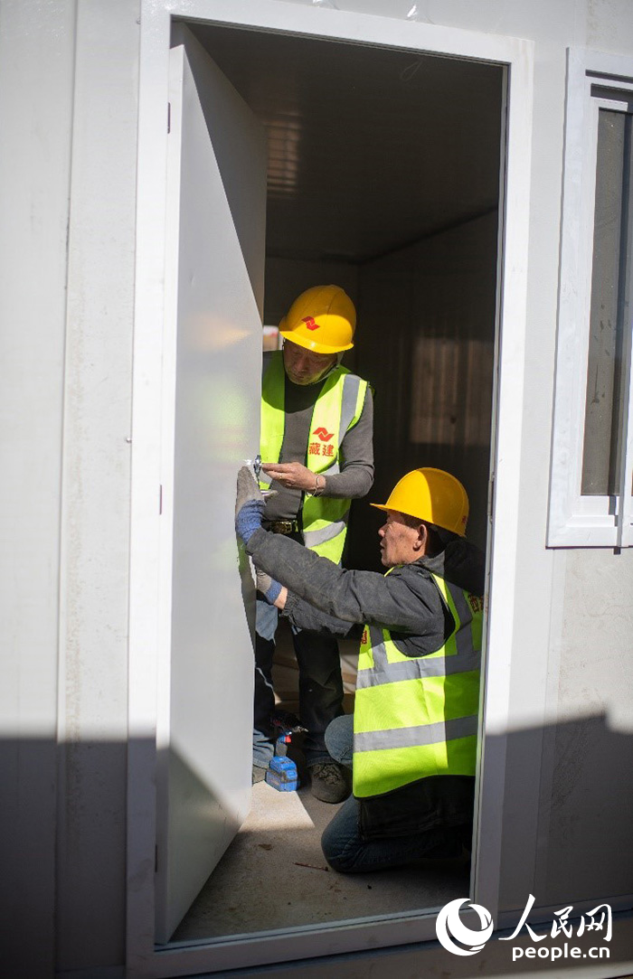 1月9日，在日喀則市定日縣長所鄉古榮村安置點，施工人員正在抓緊搭建移動板房，確保受災群眾溫暖過冬。人民網記者 翁奇羽攝