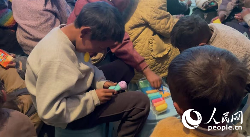 措果鄉塘仁村的孩子們正在用橡皮泥制作自己的情緒“小怪獸”。人民網記者 郝潔攝